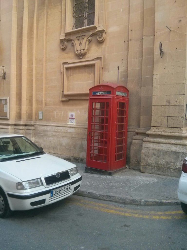 A red telephone booth in the street of Valletta