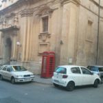 A red telephone booth in the street of Valletta