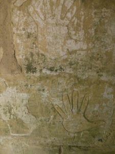 The walls of the prison are covered with graffiti. Most of it is of hands and ships. - Baby-moon