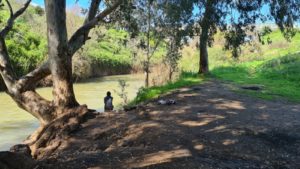Sitting on the Jordan river below the bridge