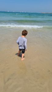 Jannaeus enjoying the sea and the sand while the planes are at the sky