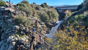 The small waterfall, and bridge crossing fhe stream.