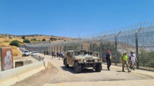 The line of cars along the border fence and an IDF Hummer