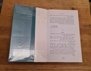 The inner side of a warped book hold down with a sellotape - Warping books