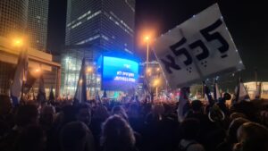 "HaHaretz - Democracy does not end at the elections" HaHaret z is a left-wing newspaper supporting the protest. Azrieli group refused at first to advertise the slogan claiming they wish to avoid politics. The sign on the right says To the Prison