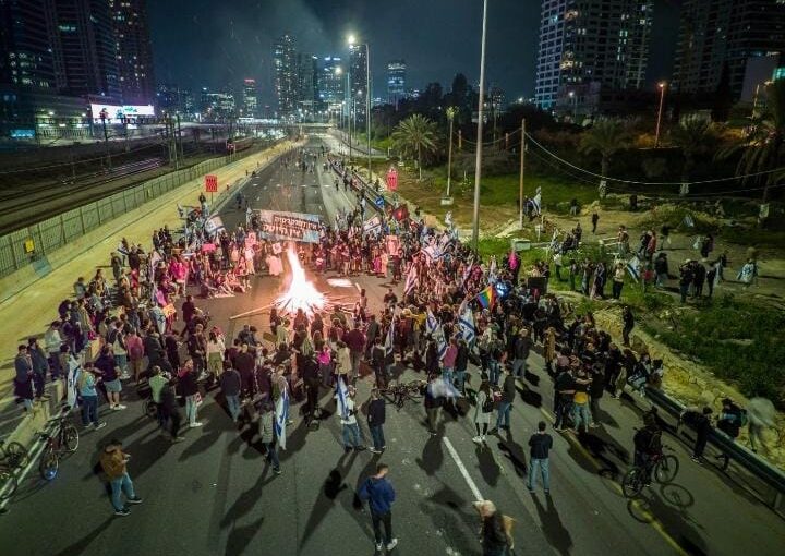 Protestors standing around a firecamp in Ayalon Highway (Tomer Applebaum, HaHaretz)