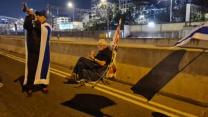 protestor sitting quietly with his sleepers and smoking a cigarette...