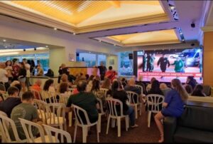 The evacuated citizens of Be'eri watching the TV broadcast of what was supposed to be the release of hostages from Be'eri (Source: HaHaretz) - cease fire 