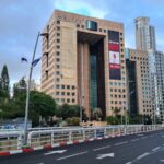 Bring the home now, sign on a building on Ramat Gan Diamond Exchange district. The hostage picture on it is of Omri Meiran, 46 years old from Kibbutz Nahal Oz.