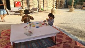 Jannaeus and Mindal making bottles with layers of colorful sand did keep them busy for ten minutes - Kfar HaNokdim 
