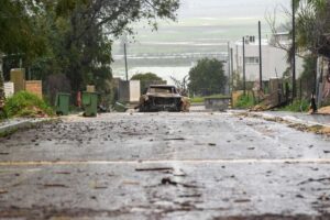 A burnt car hit by an anti-tank missile in the street if Metula