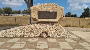 A rock, from Sinai, with a metal plate in it sits on Rujum (pile of rocks) - Be'eri temporary cemetery 