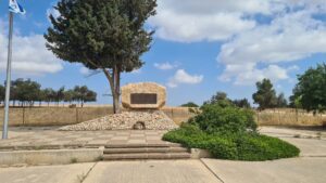 The monument and the tree on top of a low platform - Be'eri temporary cemetery