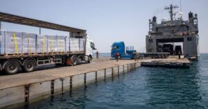 A loading craft unloading trucks on the floating dock  (Source:  https://t.me/abualiexpress)