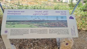The lookout on the edge of the hill: A view to the East over Gush Dan and Tel Afek. A sign on Open spaces and development