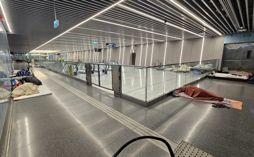 Peopela are sleeping quietly with the lights on in the AC in the ticketing floor of the station