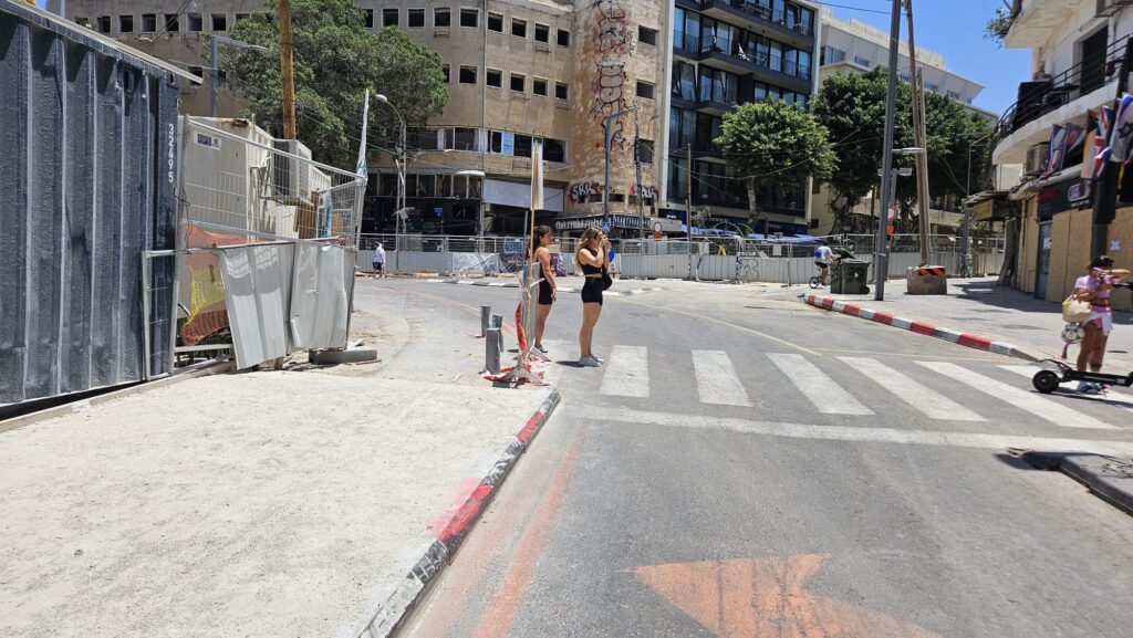Tourists taking pictures of the damages caused to the building in Allenby street in Tel Aviv, near the point an Iranian ballistic missile hit two days ago. - Disaster tourism