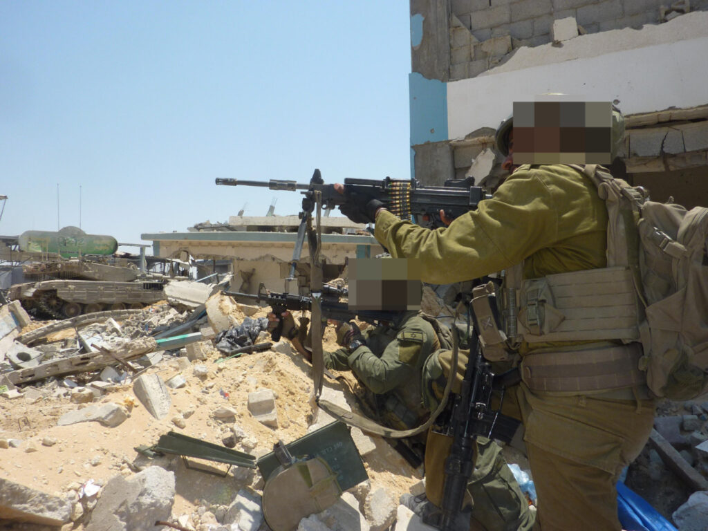 Negev light machine gun to create a firewall around us. You can also see the Tank Merkave in the background who also helps curtain from the surroundings. 