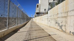 The road above the Hasbani north of the walkway, it is mostly a security road and not nice to walk - Fence on side and a concrete wall on the other