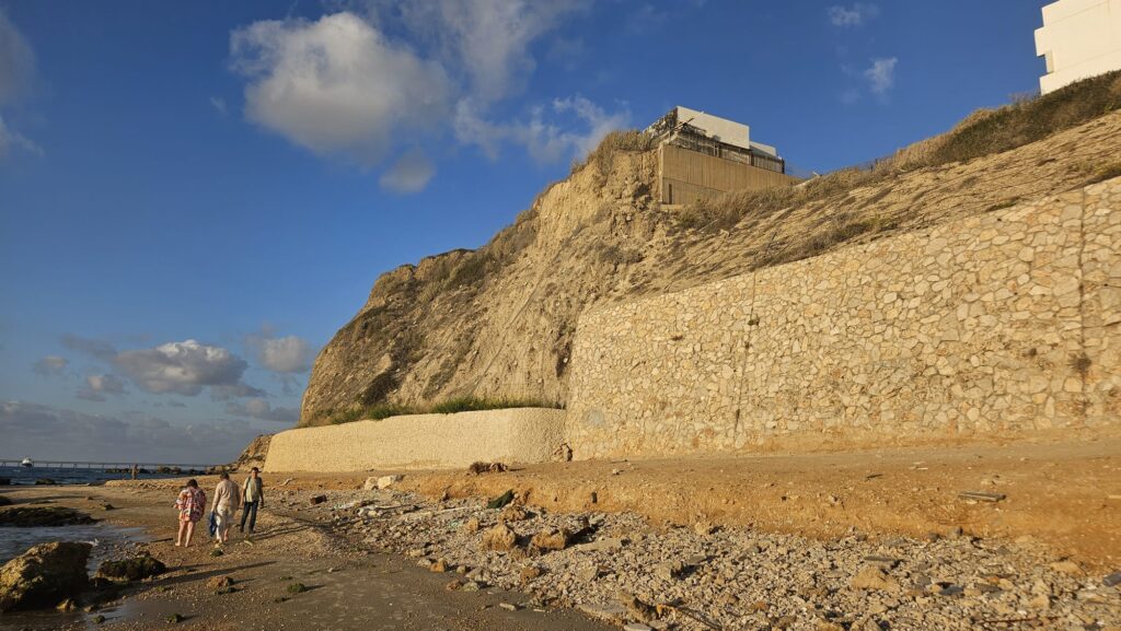 A view from the beach on the collapsing cliff the house sitting on