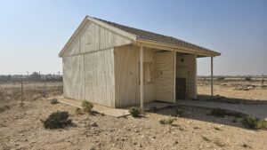 A cabin with the map of the United Nations Partition Plan for Palestine and map of the Peel Commission as well as a table with the water system built here.