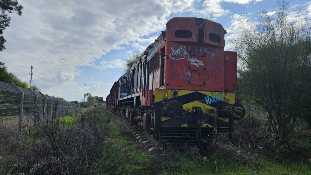 The old engine and the station building in the background. I guess they left it to be part of the future historical area to be built here, like in Jerusalem or Beer Sheva old train station (although it is not and old or historical engine), or it was just not affordable to be moved from here (Al tough I have doubts it is the original railway track, the train is sitting on)