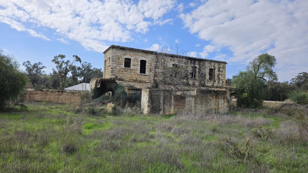 The station building front (north). The original facade is covered with newer buildings that hide it.