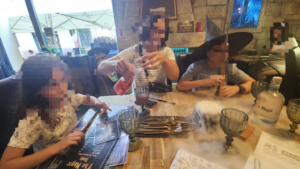 Sitting down and ordering in The Magic restaurant in Budapest, with a unique atmosphere of Harry Potter and magic vibe. Here I still let myself order a dish for myself. - Eat like Aba